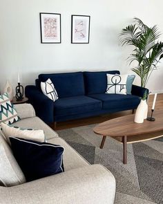 a living room with two couches, a coffee table and some pictures on the wall