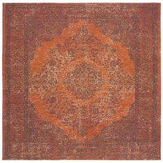 an orange and red area rug with a medallion design on the center, in front of a white background