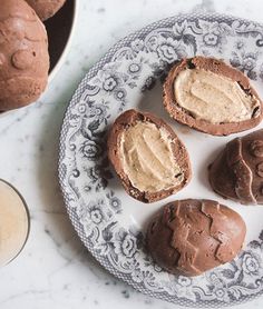 three chocolate desserts are on a plate next to a glass of milk and an empty bottle