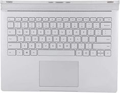 an open laptop computer sitting on top of a white surface with the keyboard and mouse