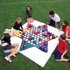 a group of people sitting around a giant board game