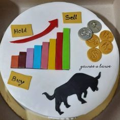 a cake that is decorated with money, coins and a bull on it's side