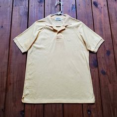 Vintage 80's men's size Large short sleeve polo shirt by Sears!! Embroidered fire breathing dragon in front. Pale light soft yellow color. Banded sleeves. Soft material. Collar with a few buttons down the front. Great vintage condition. Has been washed and will be pressed. Happy to answer any questions :) Measurements: Pit to pit - 20 1/2 inches across.  Length from shoulder to hem - 27 1/2 inches. Vintage Summer Polo Collar T-shirt, Classic Fitted Yellow Polo Shirt, Yellow Collared Polo Shirt For Summer, Yellow Polo Shirt With Collar For Summer, Summer Yellow Polo Shirt With Polo Collar, Fitted Yellow Classic Polo Shirt, Yellow Summer Polo Shirt, Retro Short Sleeve Cotton Polo Shirt, Retro Short Sleeve Polo Shirt For Spring