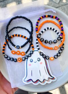 a white plate topped with halloween bracelets and a ghost sticker on top of it