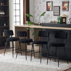 three black chairs sitting in front of a bar