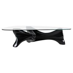 a glass table with an unusual design on the top and bottom, sitting in front of a white background