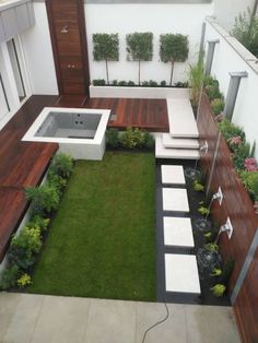 an outdoor bathtub in the middle of a garden with grass and wooden steps leading up to it