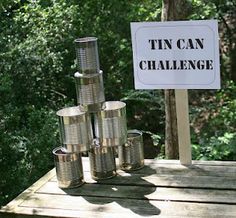 tin cans stacked on top of each other in front of a sign that says tin can challenge