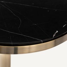 a black marble topped table with gold legs