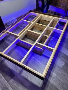 a large wooden table with blue lights on the top and bottom part, in front of a purple light