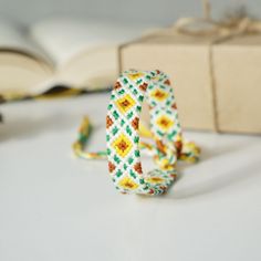 an open book sitting on top of a table next to a bracelet