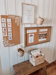 a wooden bench sitting in front of a wall with pictures on it and a basket next to it