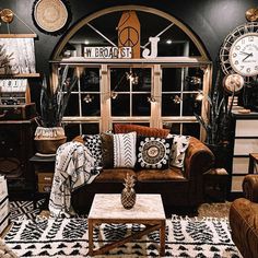 a living room filled with lots of furniture and clocks on the wall above it's windows