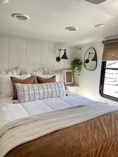 a bed in a bedroom with white walls and wooden head board on the wall next to window