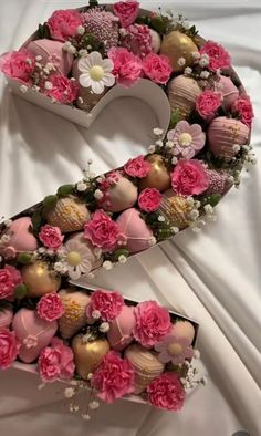 the letter s is decorated with pink flowers and chocolate candies in it's shape