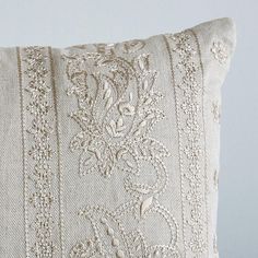 a white pillow with an embroidered design on it