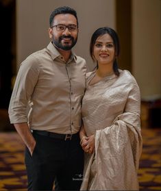 a man and woman standing next to each other in front of a carpeted floor