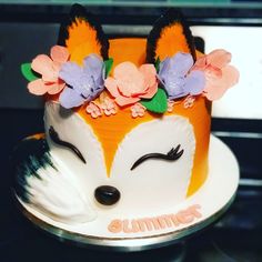 a cake decorated with flowers and an animal's face