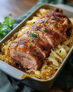 meat and onions in a casserole dish with parsley garnish on the side