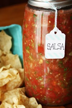 salsa and tortilla chips on a wooden table with a tag that says salsa