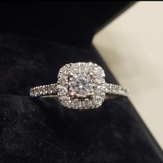 a diamond ring sitting on top of a black velvet box with its reflection in it