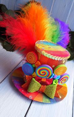 a colorful hat with lots of candy on it and a flower in the center, sitting on a white wooden surface