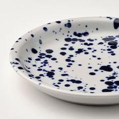 a white and blue bowl with black spots on it