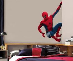 a bedroom with a spiderman wall decal on the wall