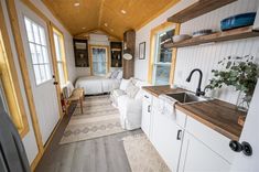 the interior of a tiny home with two beds and a kitchenette in between them