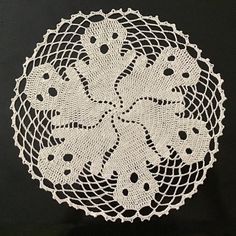 a white doily on a black shirt that has been crocheted with yarn