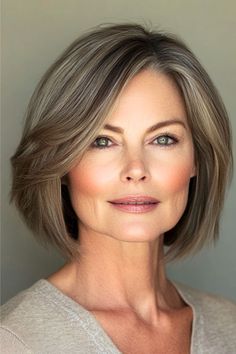 Bob with Soft Highlights Hairstyle on woman in her 50s with short brown highlighted hair.