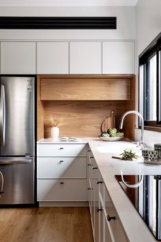 a modern kitchen with white cabinets and stainless steel appliances