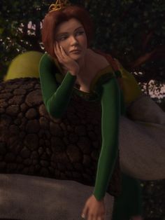 a woman in a green dress sitting on top of a tree