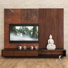 a buddha statue sitting in front of a tv on a wooden entertainment center with speakers