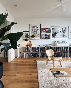 a living room filled with lots of furniture and pictures on the wall above it's bookshelf