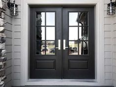 a black double door with two sidelights in front of a house