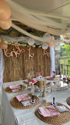 a table set up for a party with pink and white decorations