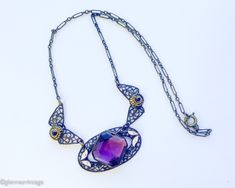 ~ 1920s gorgeous old brass filigree necklace with purple glass ~ Large faceted purple glass stone ~Old wonderful chain, paper clip style ~ Delicate enamel leaves ~ Excellent condition Length- 18" (45.5 cm) Drop when held- 8.5" (21.59 cm) More Fantastic Vintage Jewelry:  glennasvintageshop.etsy.com Additional Vintage in our sister shop Glenna's Jewels:  glennasjewels.etsy.com Instagram @glennas_clothing Facebook https://www.facebook.com/glennasclothing Formal Purple Metal Necklace, Antique Purple Metal Jewelry, Vintage Purple Filigree Necklace, Purple Vintage Filigree Necklace, Antique Handmade Purple Jewelry, Handmade Antique Purple Jewelry, Purple Filigree Pendant Necklace, Purple Pendant Necklace With Filigree, Purple Amethyst Jewelry With Soldered Details