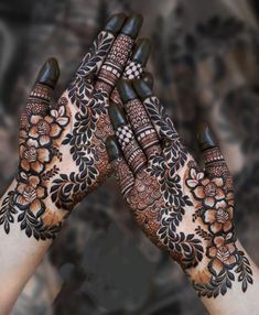 two hands with henna designs on them