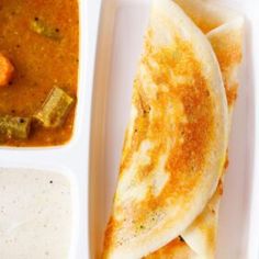 a white plate topped with food next to a bowl of soup