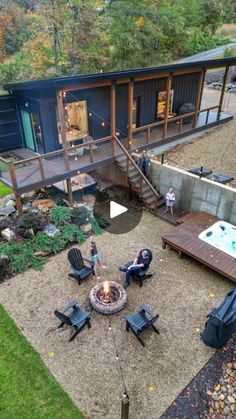 an aerial view of a house with a hot tub in the yard and people sitting around it