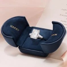 an engagement ring in a blue velvet box with the name harry written on it's side