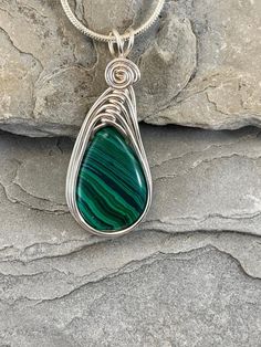 This Malachite necklace is simple yet elegant.  Malachite is a beautiful green color with unique striping/bands of color. I chose to enhance this beautiful smoothstone with a Celtic inspired silver wire design to let the natural beauty of the gemstone shine. This necklace is handmade by me with a synthetic malachite stone The necklace you will receive will be similar to the one in the picture, each stone is unique. The 4th photo in my listing shows the subtle variations of these Beautiful genuin Handmade Green Malachite Necklaces, Green Malachite Handmade Necklace, Handmade Green Malachite Necklace, Green Malachite Wire Wrapped Jewelry, Green Wire Wrapped Pendant Necklace, Green Wire Wrapped Teardrop Jewelry, Green Teardrop Wire Wrapped Jewelry, Green Oval Malachite Necklaces, Green Natural Stone Teardrop Pendant Necklace