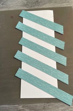 several strips of paper are laid out on top of a piece of white and blue paper