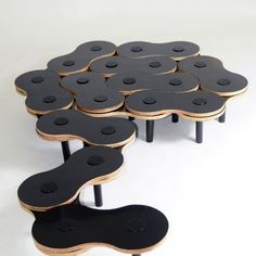 three tables made out of black and gold wood with holes in the middle on each side