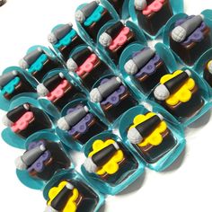 a bunch of toy cars sitting on top of each other in small plastic containers,