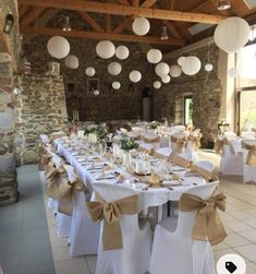 tables are set up with white linens and paper lanterns