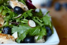 a salad with chicken, blueberries and lettuce