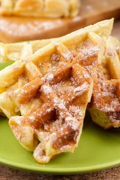 waffles on a green plate with powdered sugar