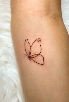 a small tattoo on the leg of a woman with a butterfly in it's center